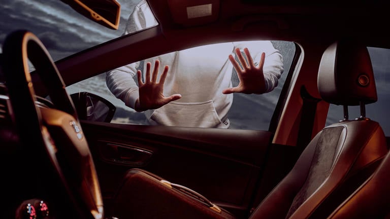 Image of a persons hands on a car window