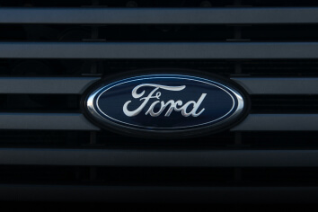 A Ford badge on the front of a black car.