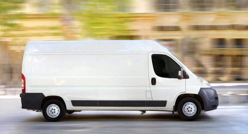 A white van driving on the road.