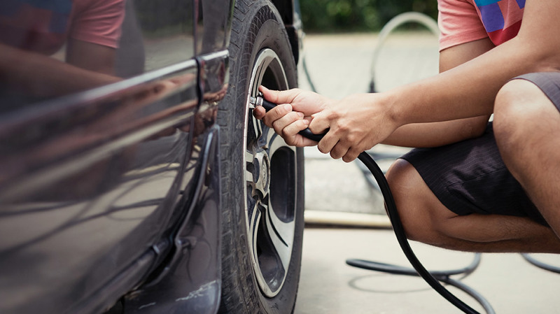 Person checking tyre pressure