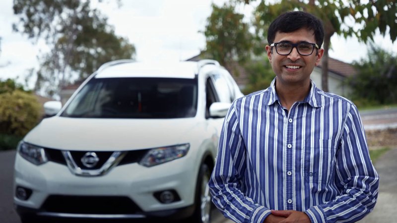 Saurabh smiling in front of car