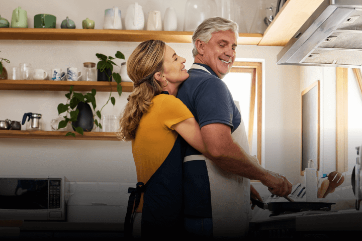 Happy retired couple cooking together in their kitchen