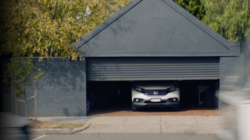 Car parked in a garage with roller down coming down