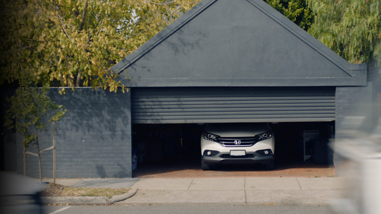 Car parked in a garage with roller down coming down