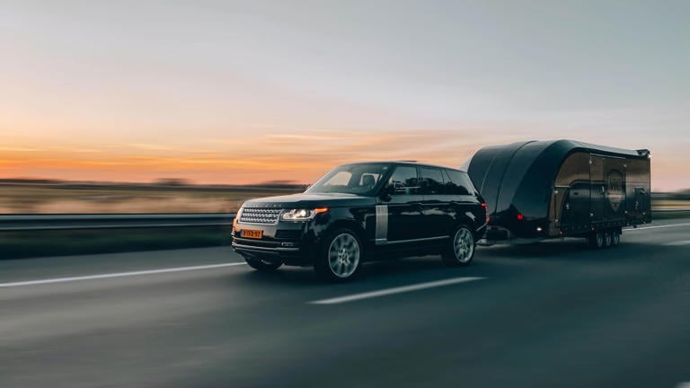 Car towing a caravan on an empty motorway