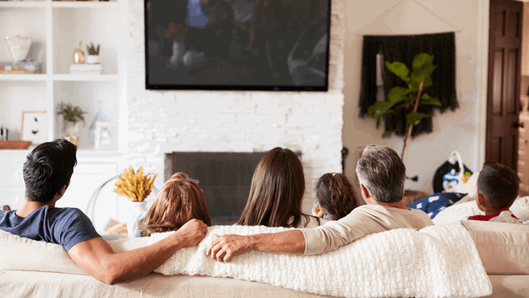 Family sitting on the couch watching television