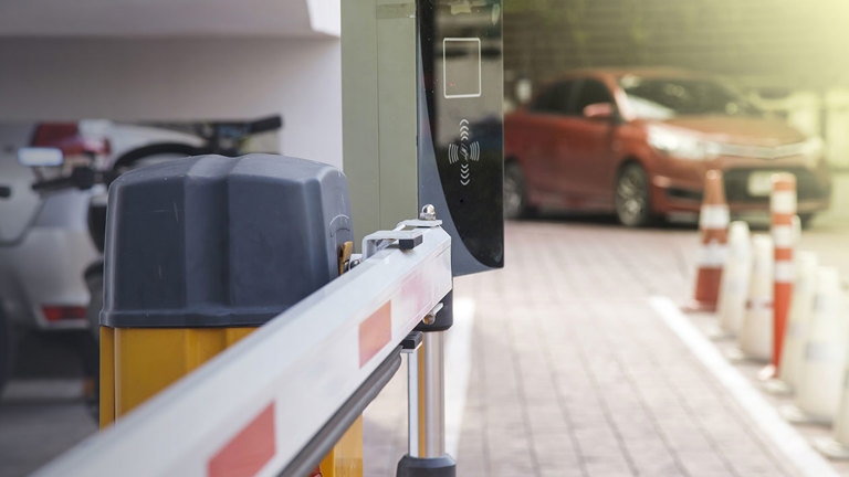 Car entering a paid parking through a boom gate