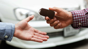 Car dealership handing over keys to a buyer