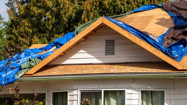 House roof with tarp covered holes