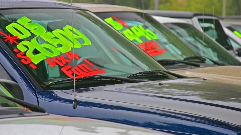 Second hand car sales yard with window stickers
