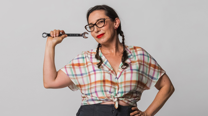Eleni smiling holding a spanner.
