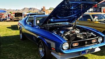 Mustang on display with bonnet open at car show on the grass