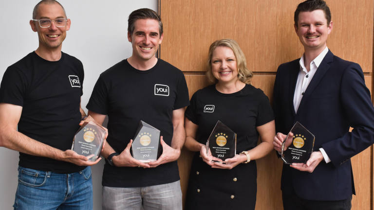 Group of 4 people holding awards