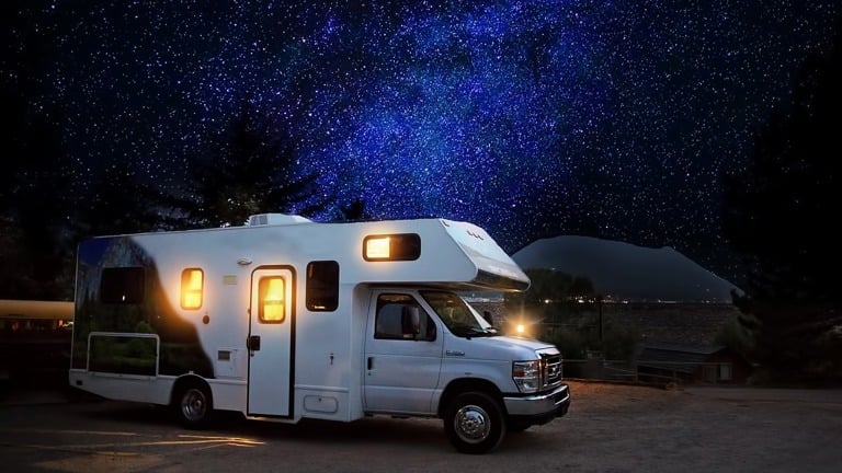 Caravan at night parked under the stars