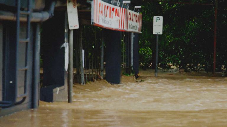 Flood waters rushing under a barrier