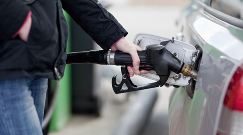 Man pumping gas into car at bowser