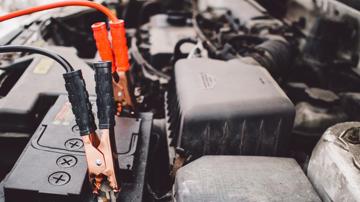 A car battery with jumper cables attached