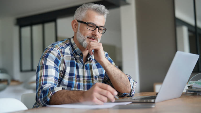 Man on computer researching home insurance