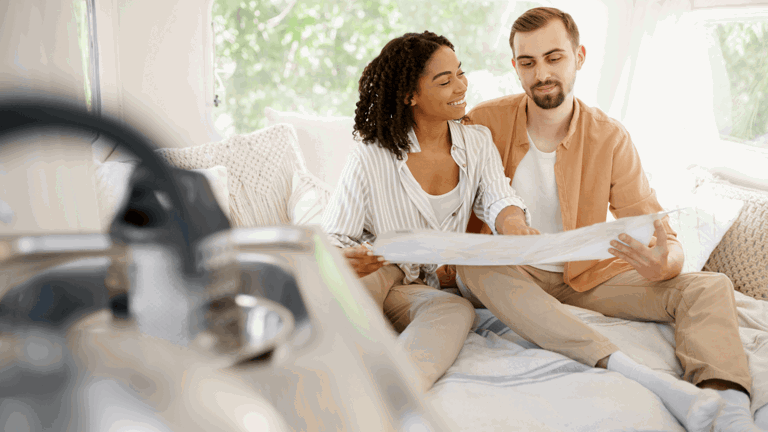 Couple sitting in a caravan looking at a map