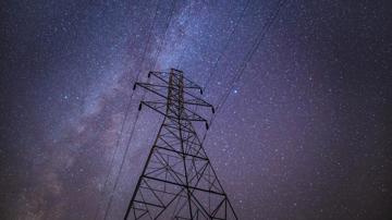 Power lines with stars in the night sky