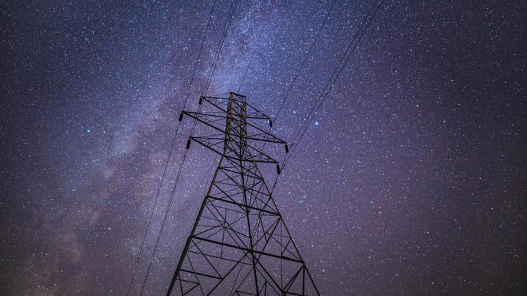 Power lines with stars in the night sky