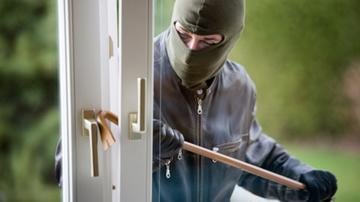 Thief breaking into a house with a crowbar