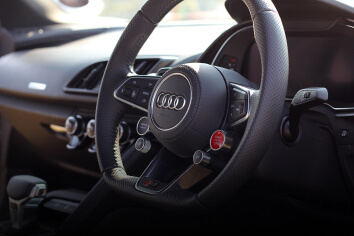 A black leather Audi steering wheel.