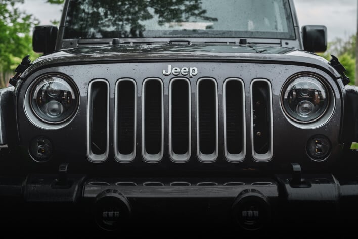 The front grill of a grey Jeep.