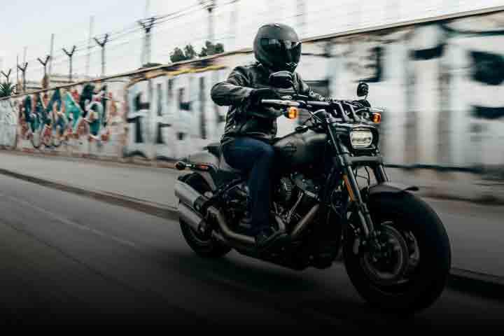 Person on a motorbike riding down a street.