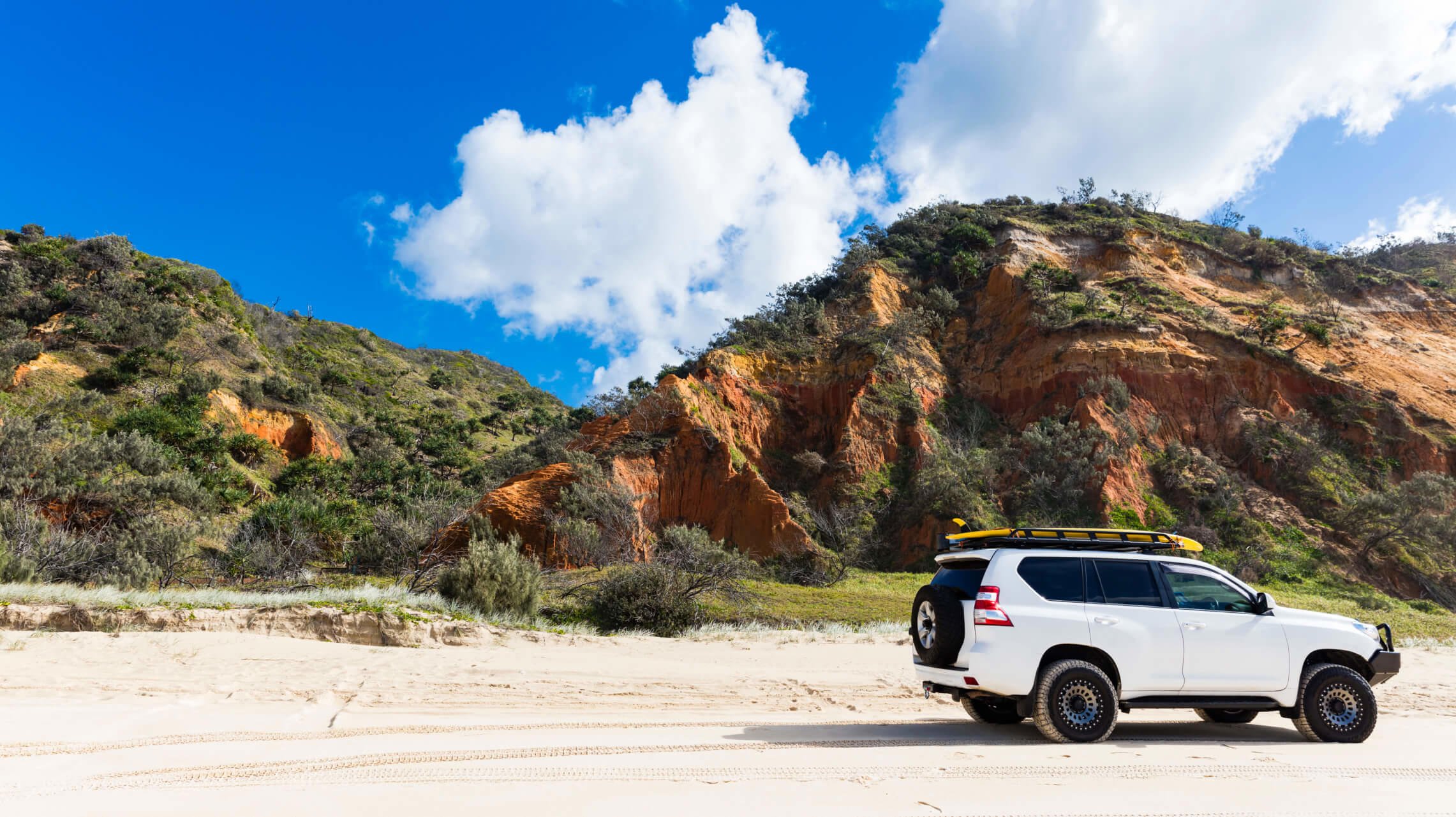 White 4wd parked on a beach