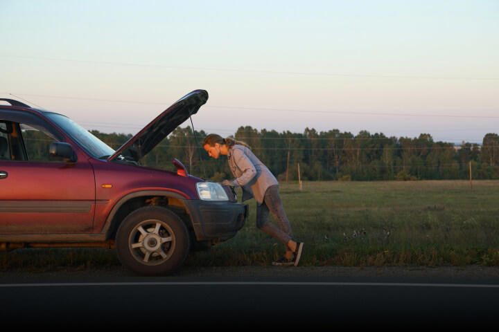 A woman broken down on the side of the road.