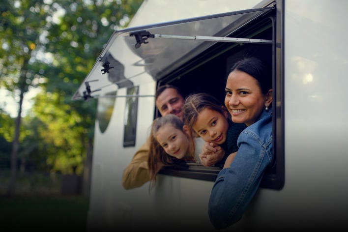 A family in the window of their caravan